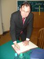Poseł Arkadiusz Mularczyk składa podpis do księgi pamiątkowej